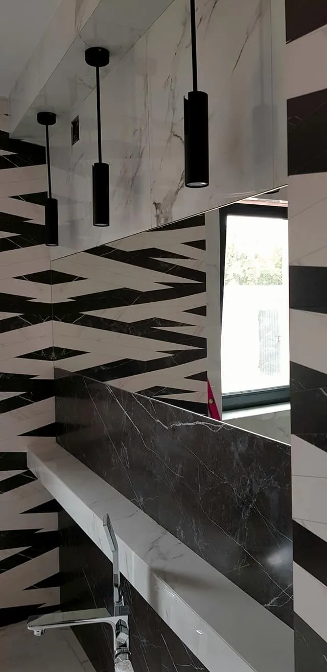 Lustro bezramowe w łazience — czarno-białe geometryczne kafelki